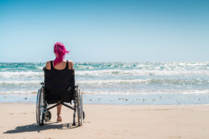 Disabled woman in the wheelchair at the beach